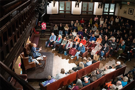 A speaker presenting to an audience at an event